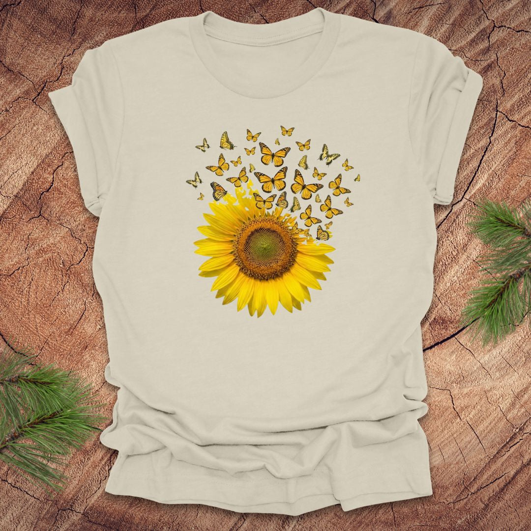 Beige t-shirt with a sunflower and butterfly design on a wooden surface
