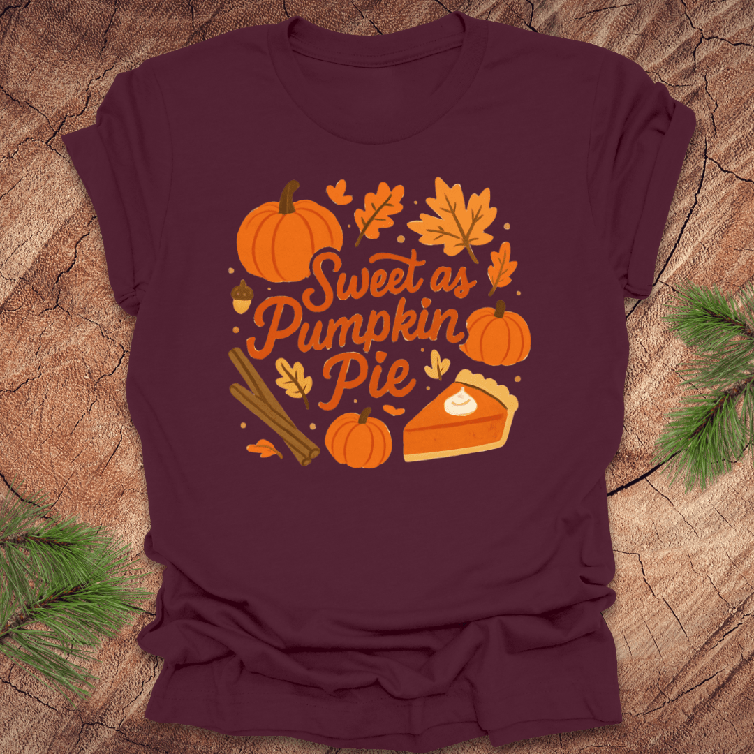 Maroon t-shirt with 'Sweet as Pumpkin Pie' design on a wooden surface with leaves.