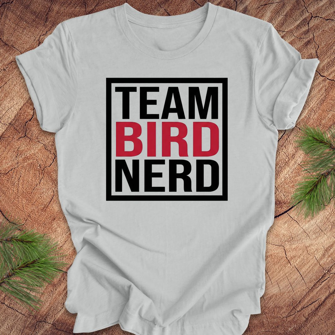 Gray t-shirt with 'Team Bird Nerd' text on a wooden surface