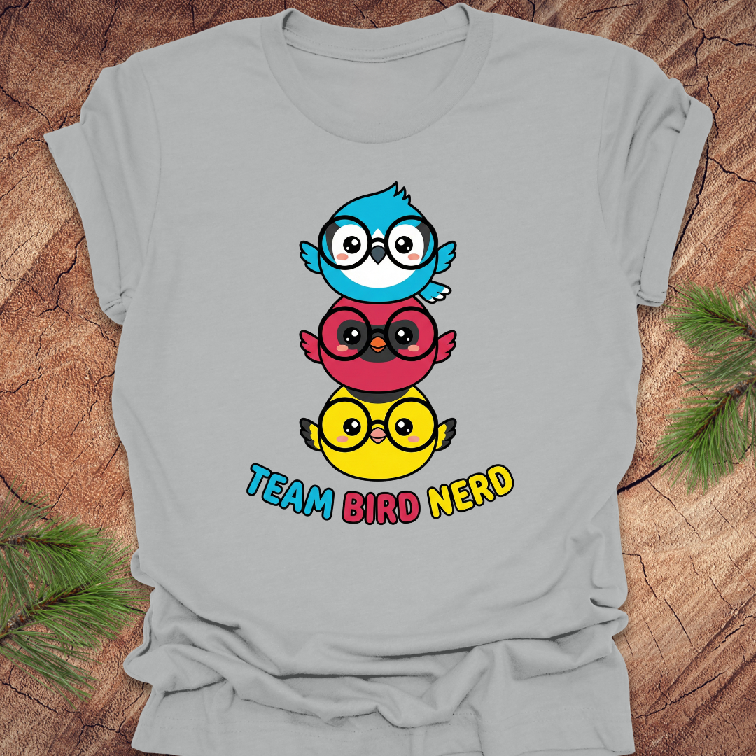 Gray t-shirt with colorful cartoon birds and 'Team Bird Nerd' text on a wooden surface.