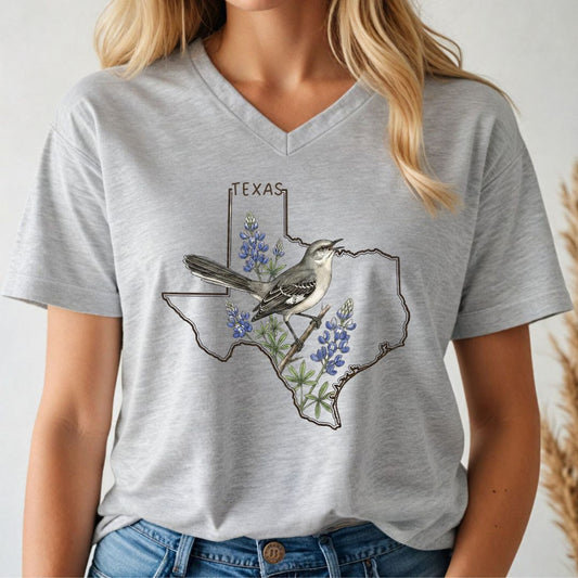 Person wearing a gray t-shirt with a Texas map design featuring a bird and bluebonnets.