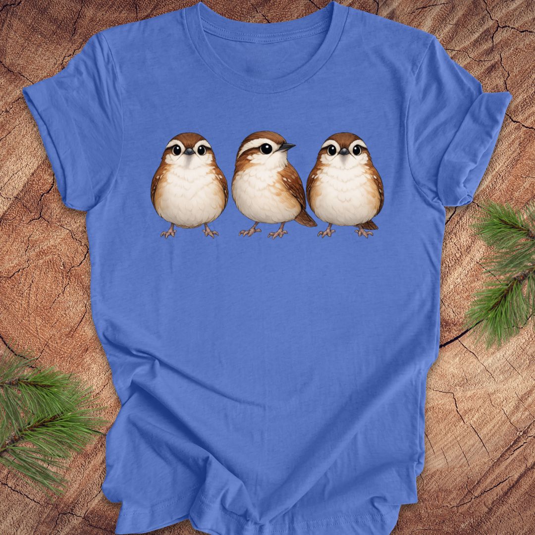 Blue t-shirt with three carolina wren birds on a wooden surface