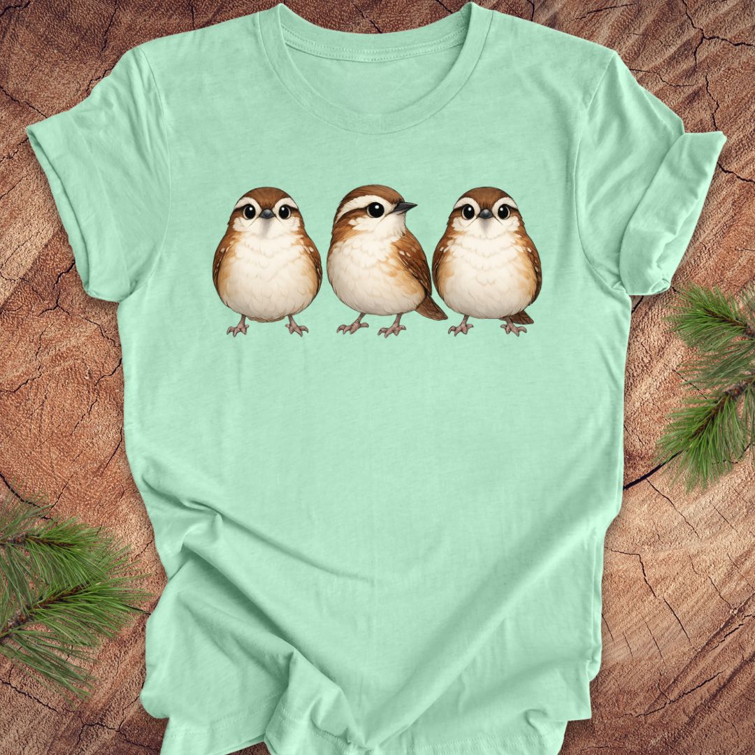 Mint green t-shirt with three carolina wren birds on a wooden surface