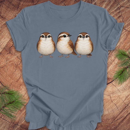 Blue t-shirt with three carolina wren birds on a wooden surface