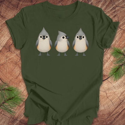 Green t-shirt with 3 titmouses design on a wooden surface