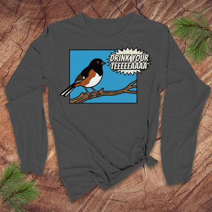 Gray long-sleeve shirt with a towhee bird graphic and text, 'drink your tea' on a wooden surface.