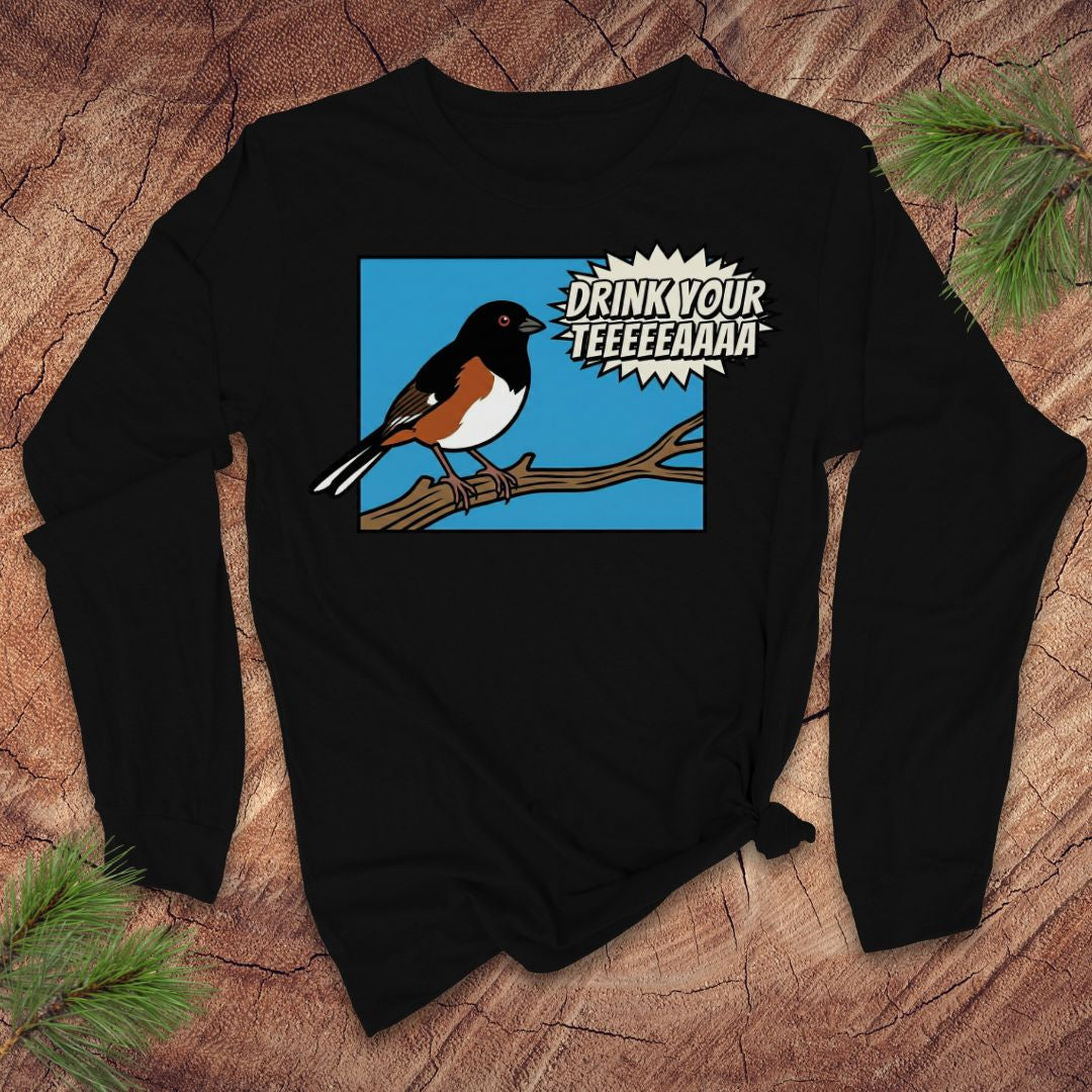 Black long-sleeve shirt with a towhee bird graphic and text, 'drink your tea' on a wooden surface.