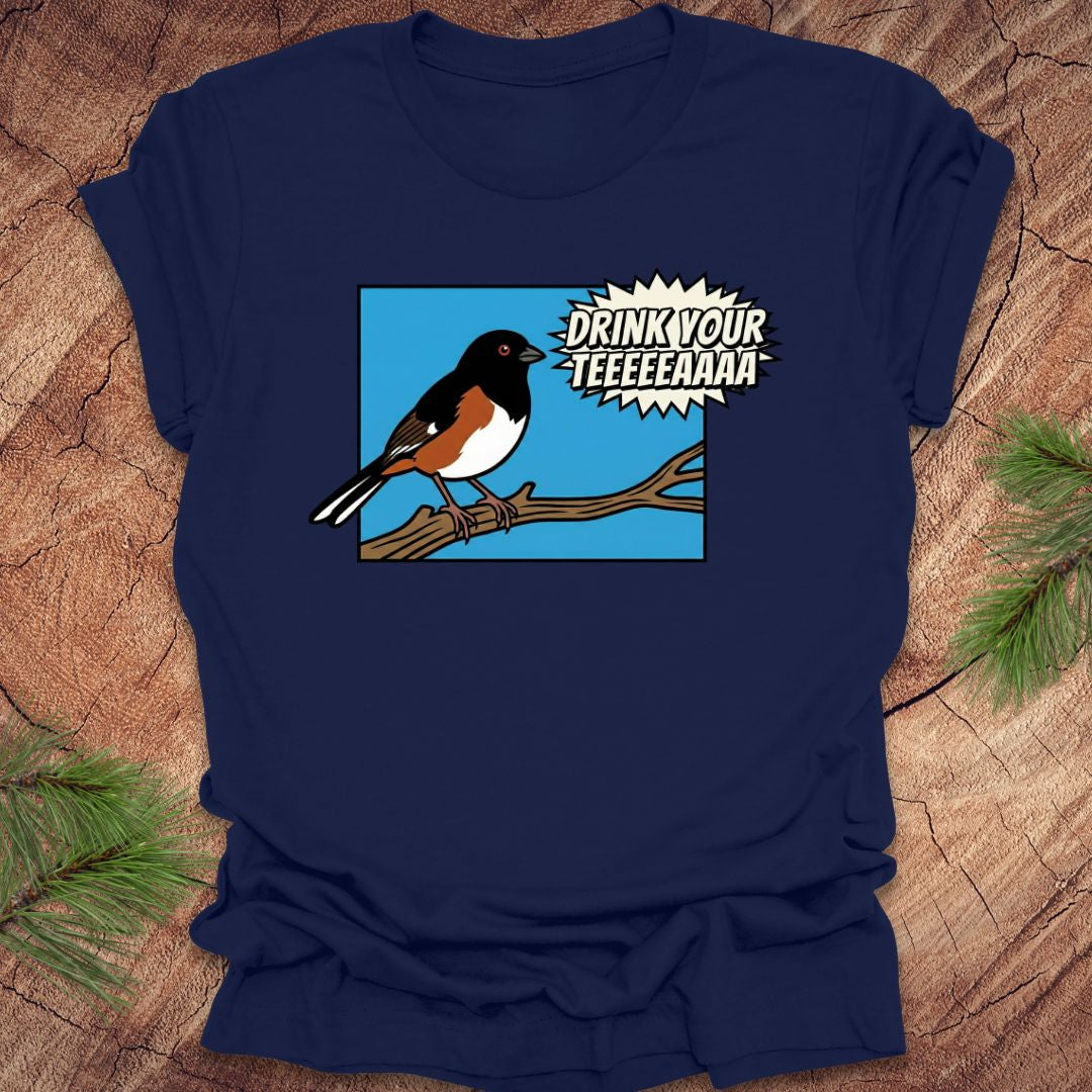 Navy blue t-shirt with a cartoon towhee bird graphic and text, 'drink your teeeaaa" on a wooden surface.