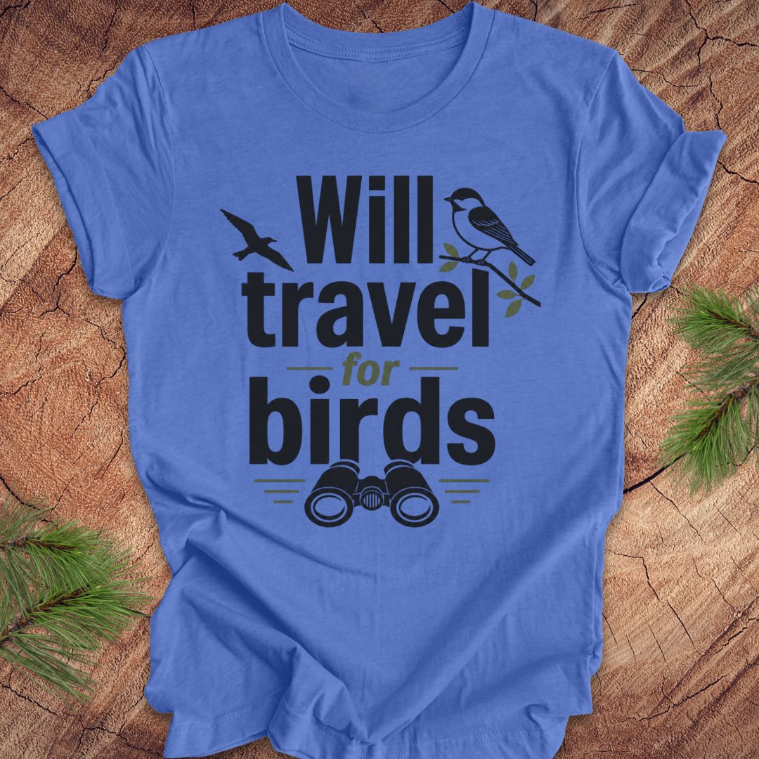 Blue t-shirt with text, 'will travel for birds' on a wood background. 