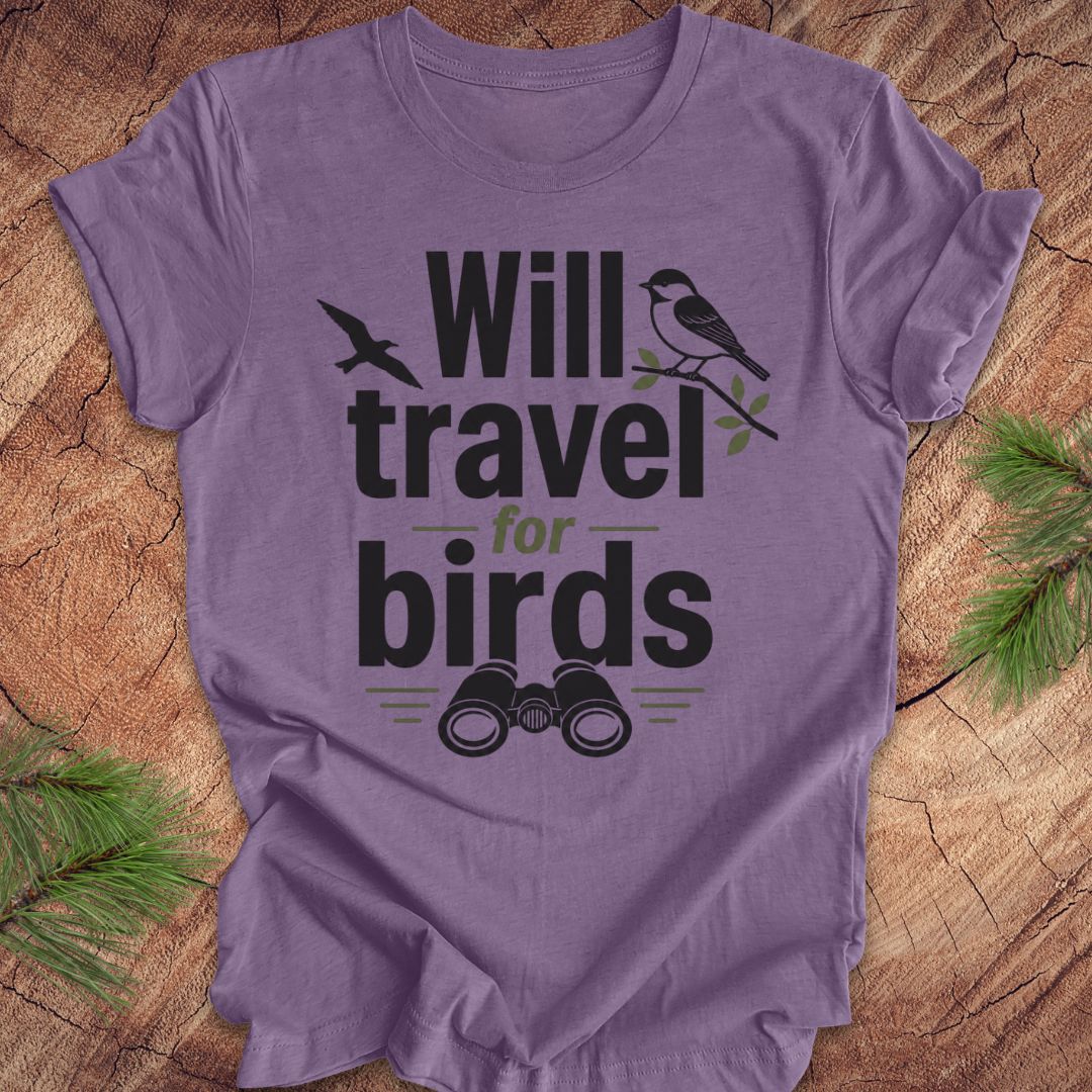 Purple t-shirt with text, 'will travel for birds' on a wood background. 