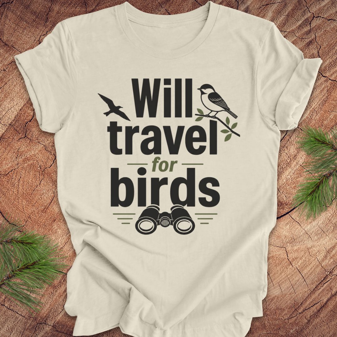 Beige t-shirt with text, 'will travel for birds' on a wood background. 
