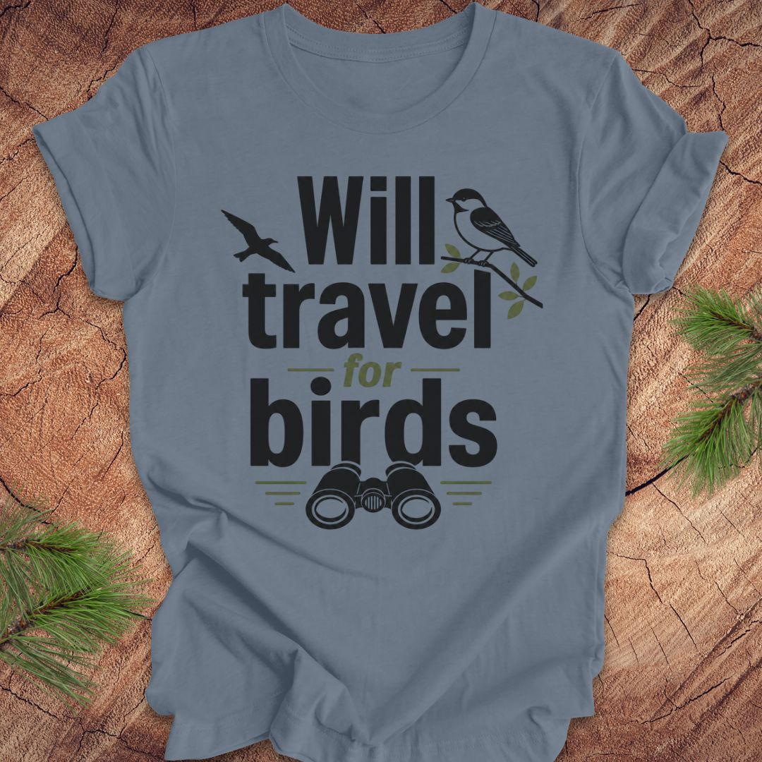 Blue t-shirt with text, 'will travel for birds' on a wood background. 