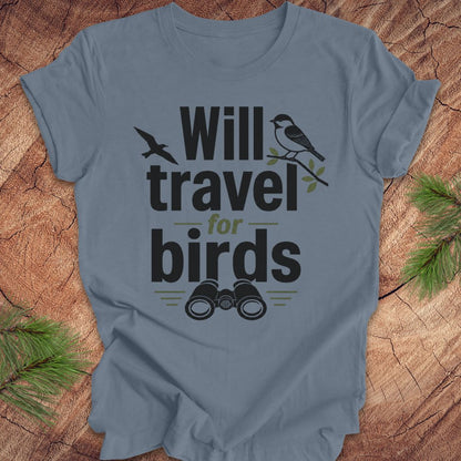 Blue t-shirt with text, 'will travel for birds' on a wood background. 