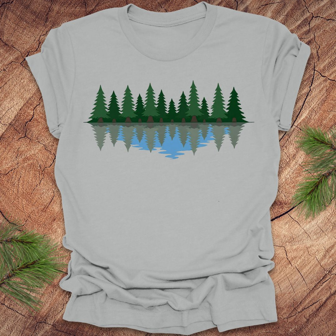 Gray t-shirt with a forest design on a wooden surface