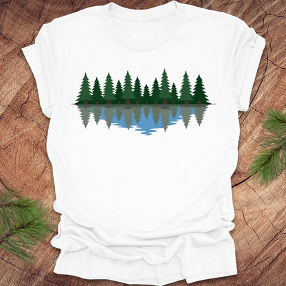 White t-shirt with a forest design on a wooden surface