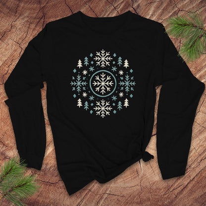 Black long sleeve tshirt with snowflake and tree design on a wooden surface