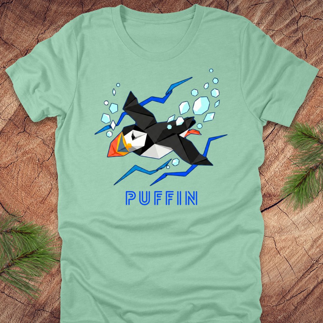 Light green t-shirt with a puffin graphic and 'PUFFIN' text on a wooden surface.