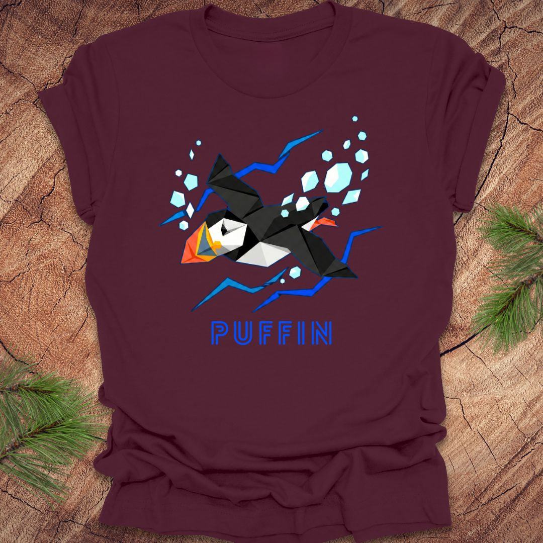 Maroon t-shirt with a puffin graphic and 'PUFFIN' text on a wooden surface.
