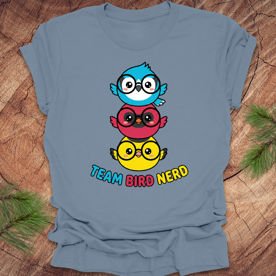 Blue t-shirt with cartoon birds and 'Team Bird Nerd' text on a wooden surface.