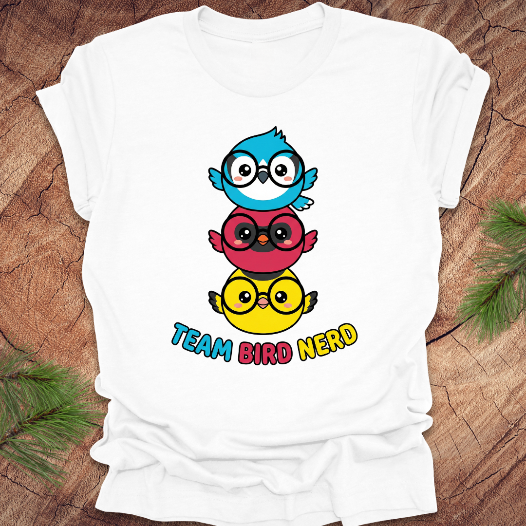 White t-shirt with colorful bird design and 'Team Bird Nerd' text on a wooden surface.
