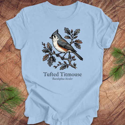 Light blue t-shirt with a tufted titmouse illustration on a wooden surface
