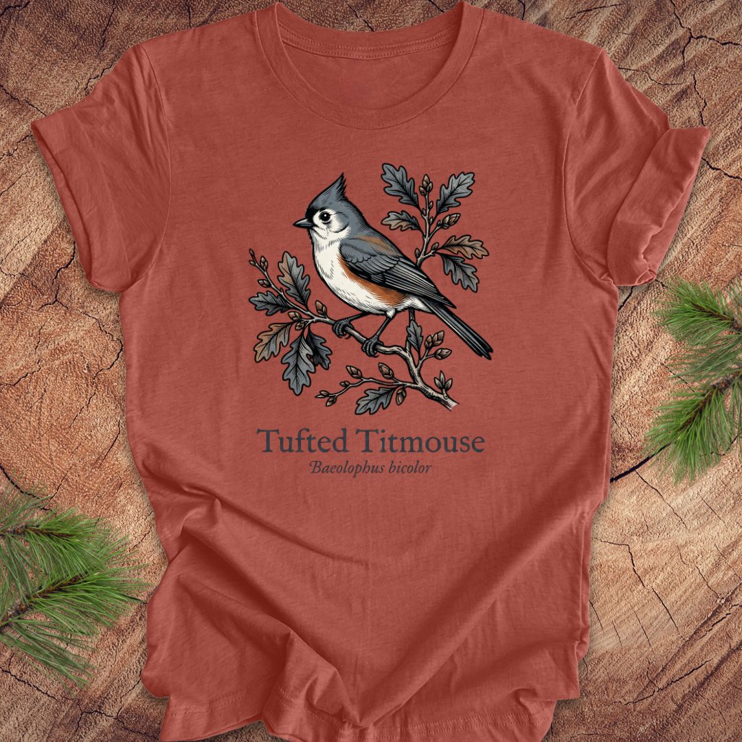 Clay colored t-shirt with a tufted titmouse graphic on a wooden surface