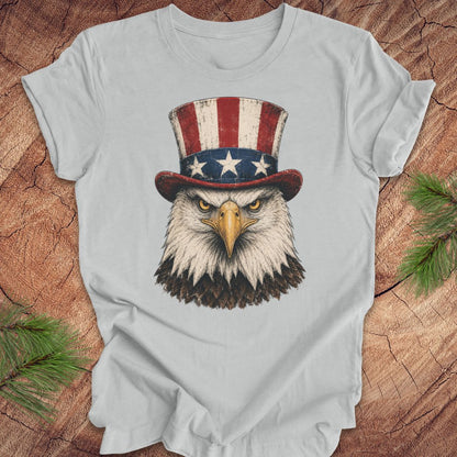 Gray t-shirt with an eagle wearing an Uncle Sam hat on a wooden surface