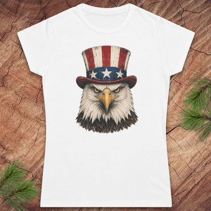 White t-shirt with an eagle wearing an American flag hat on a wooden surface.