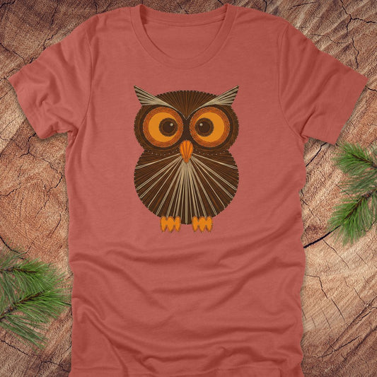 Clay colored t-shirt with a vintage owl design on a wooden surface