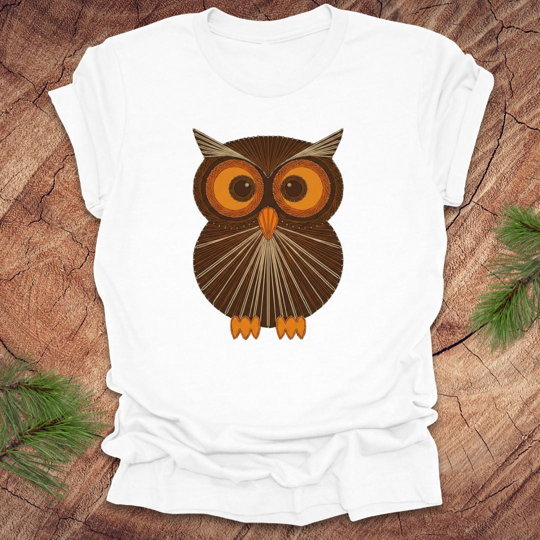 White colored t-shirt with a vintage owl design on a wooden surface