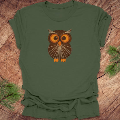 Green t-shirt with a vintage string art owl in browns and oranges on a wood background.