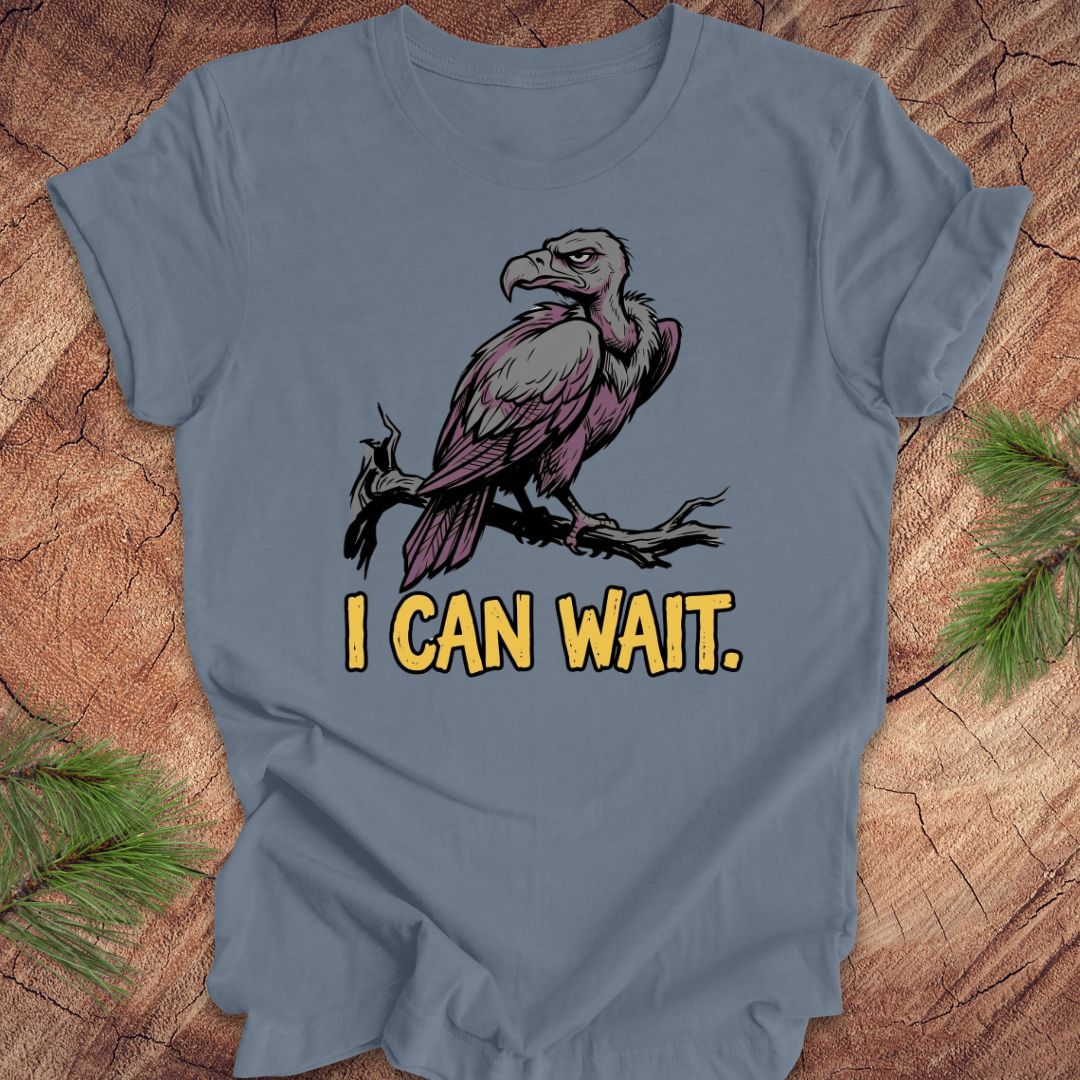 Blue t-shirt with an eagle graphic and 'I CAN WAIT.' text on a wooden surface.