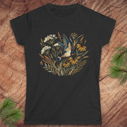 Black t-shirt with a floral and bird design on a wooden surface