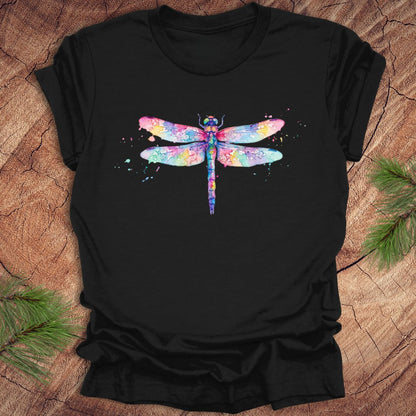 Black t-shirt with a hand painted pastel watercolor dragonfly on a wood background.