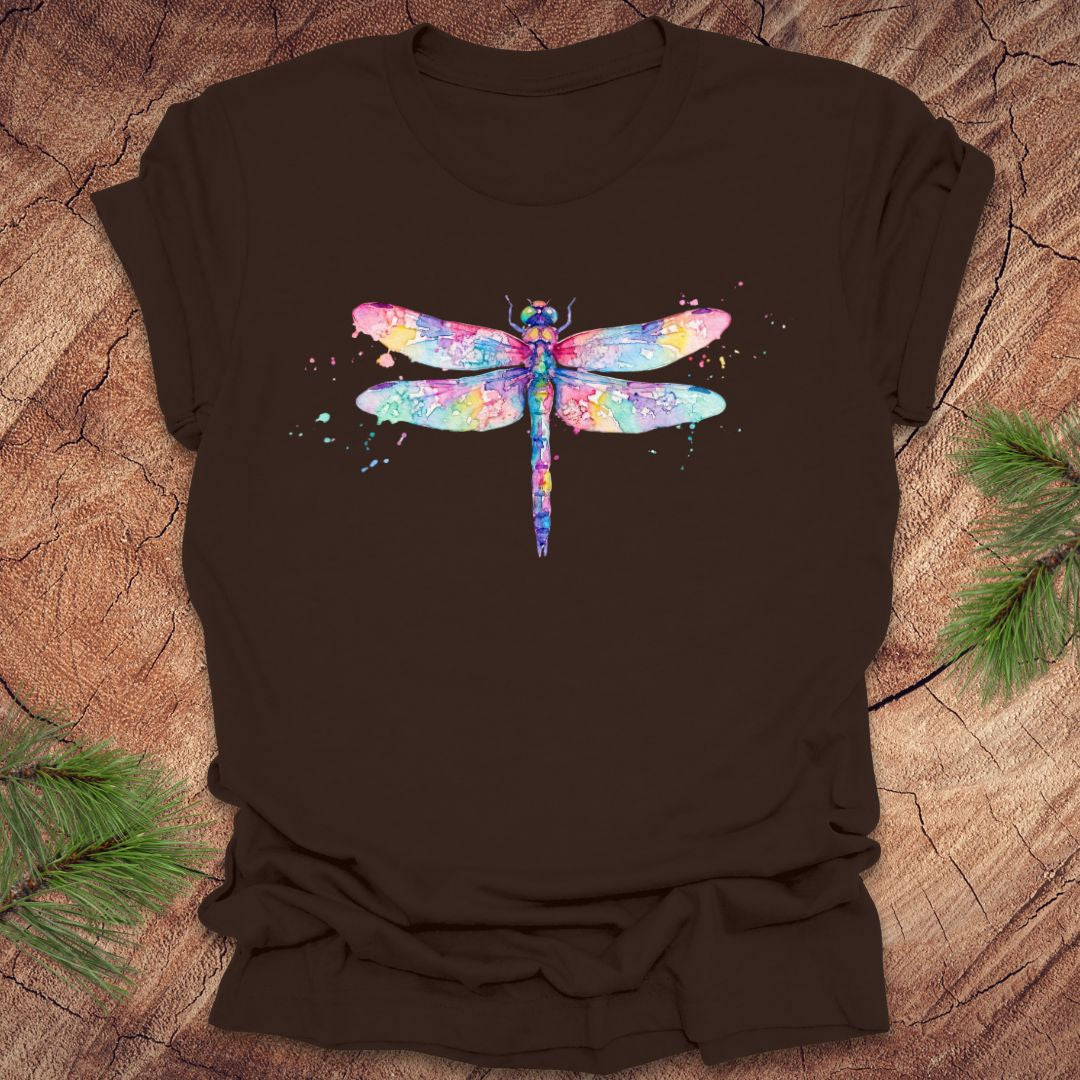 Brown t-shirt with a hand painted pastel watercolor dragonfly on a wood background.