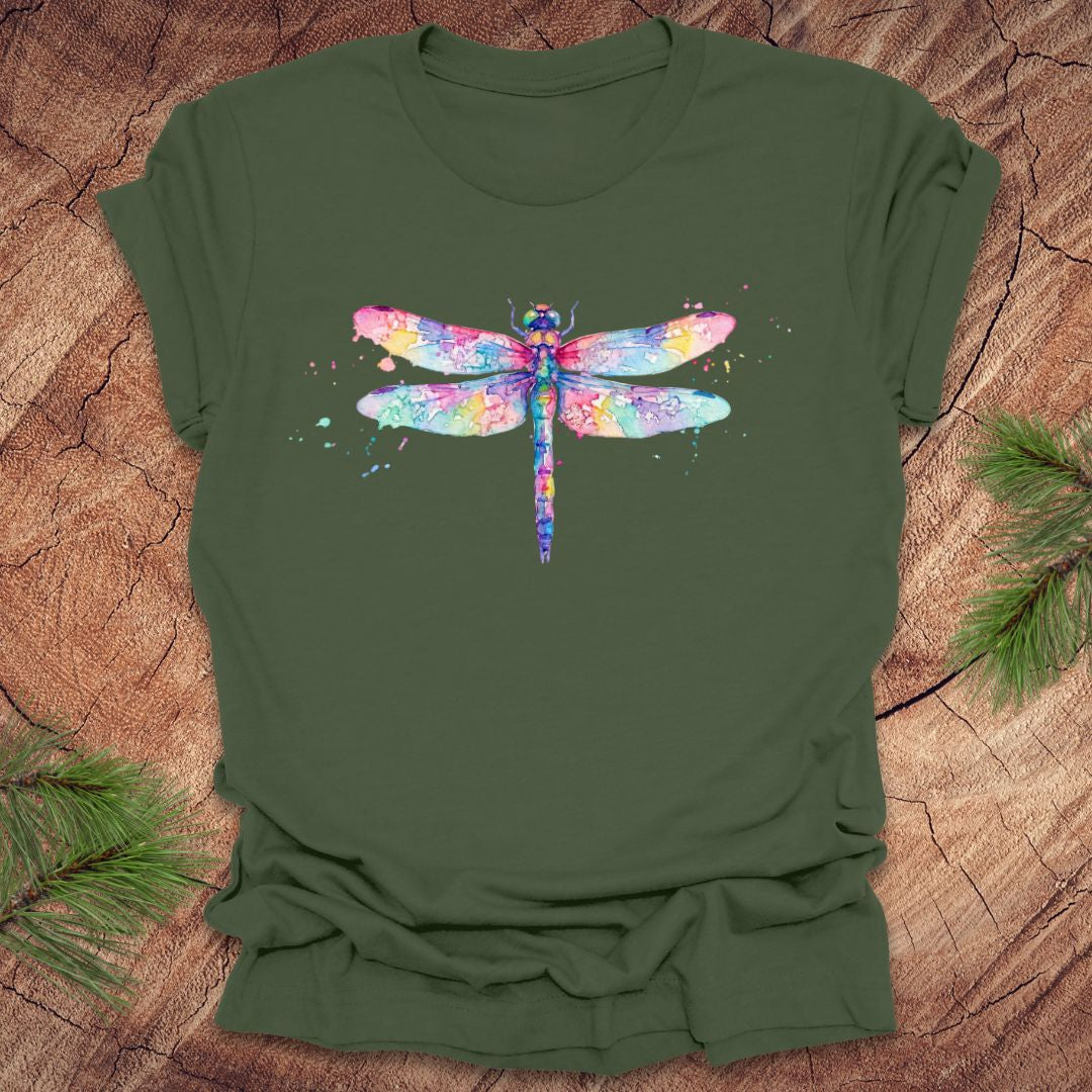 Green t-shirt with a hand painted pastel watercolor dragonfly on a wood background.