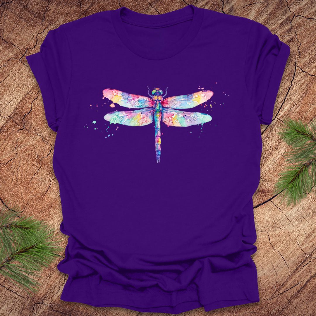 Purple t-shirt with a hand painted pastel watercolor dragonfly on a wood background.