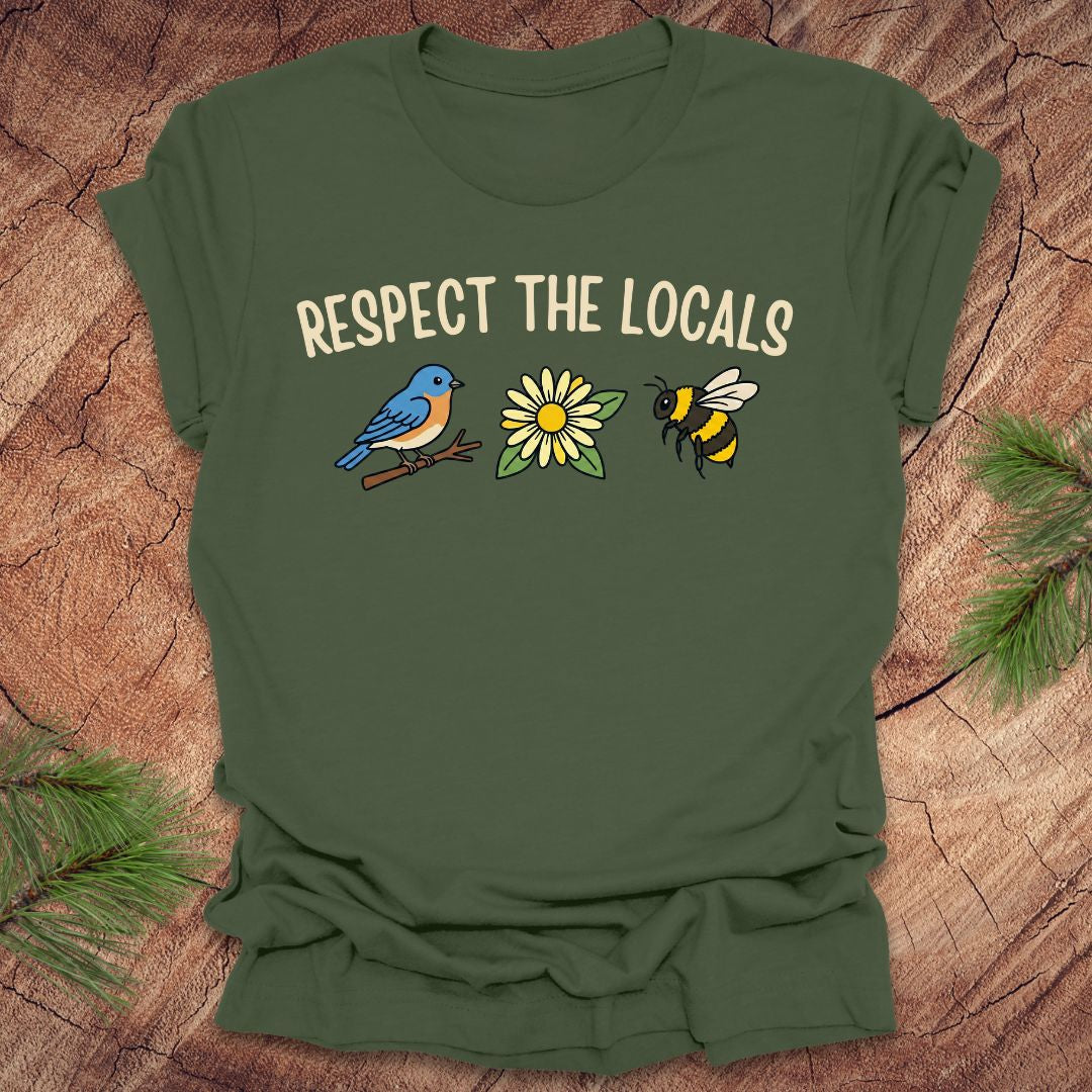 Green t-shirt with 'Respect the Locals' text and bird, flower and bee graphics on a wooden surface