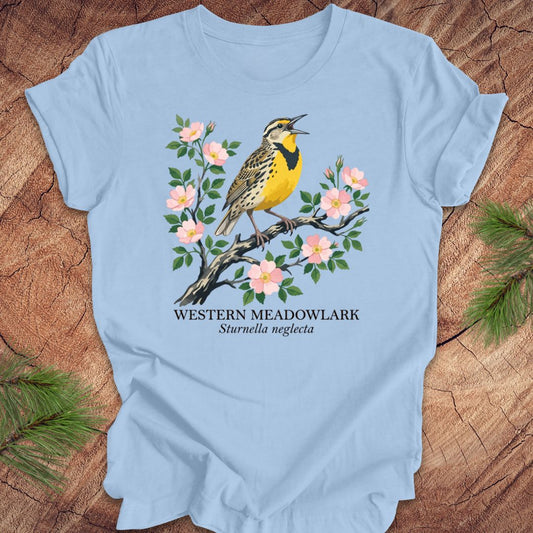 Light blue t-shirt with a Western Meadowlark graphic on a wooden surface