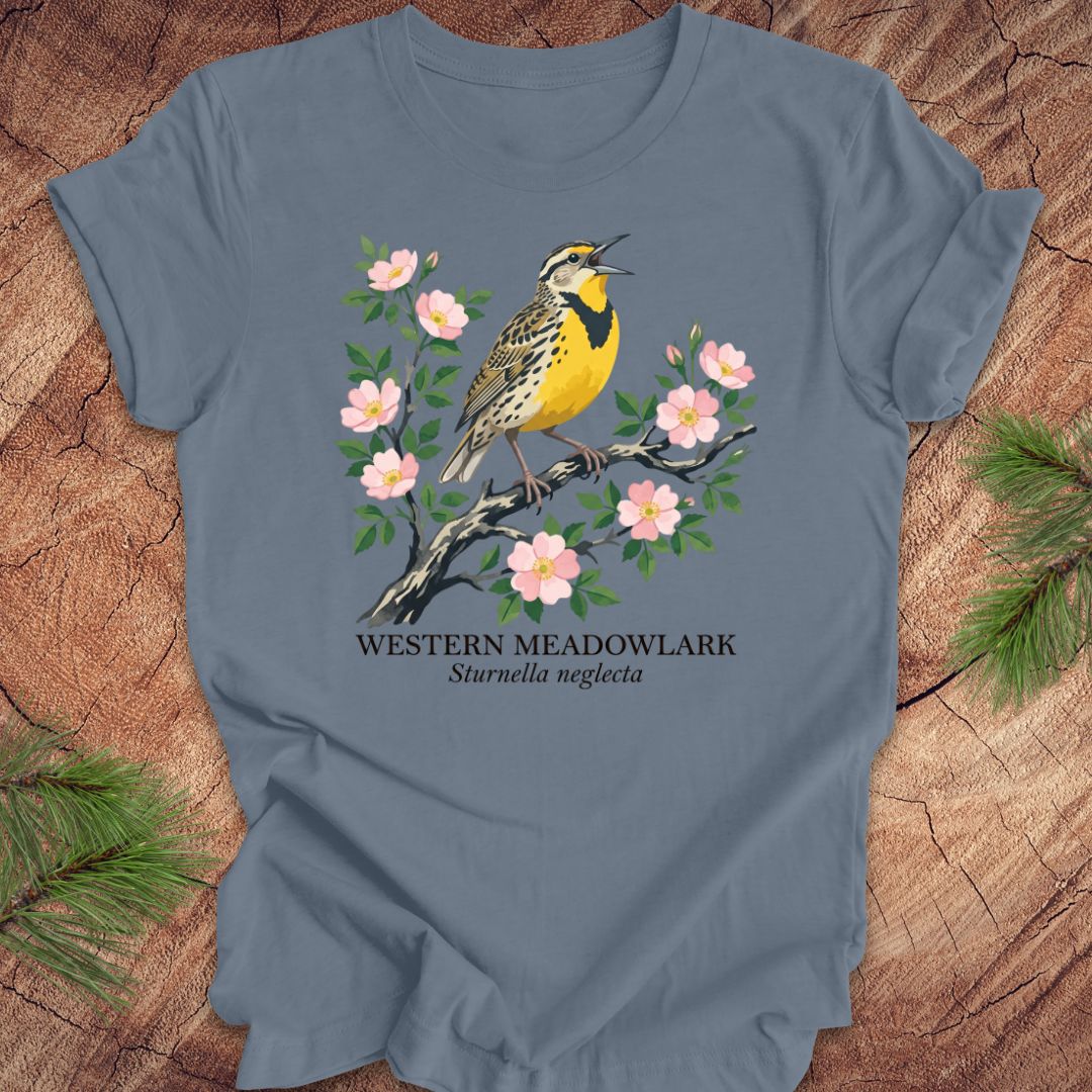 Blue t-shirt with a Western Meadowlark design on a wooden surface