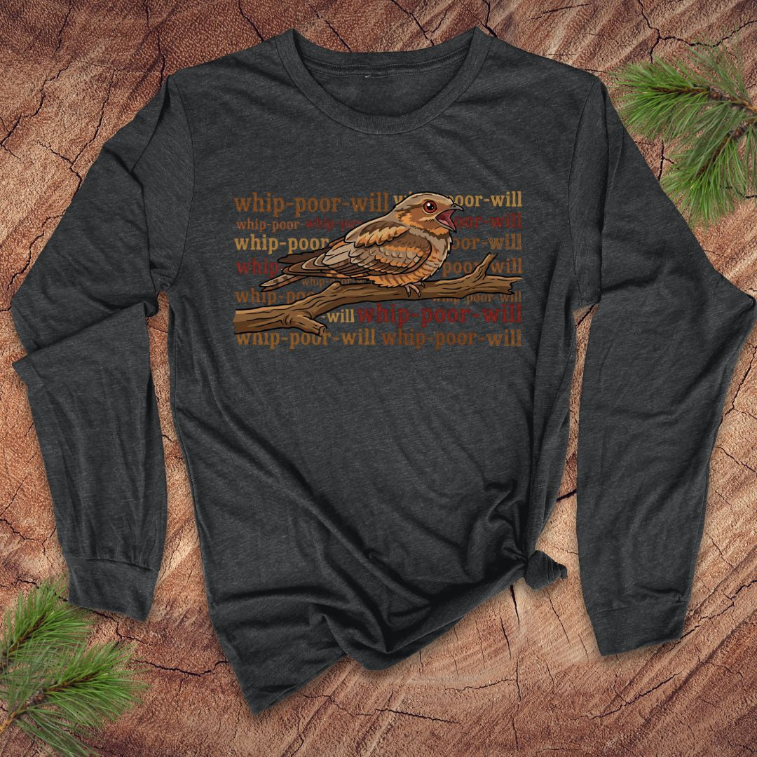 Dark Gray long-sleeve shirt with a bird graphic and repeated 'whip-poor-will' text on a wooden surface.