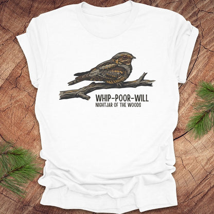 White t-shirt with a whip-poor-will bird on a branch with text 'nightjar of the woods' on a wood background.