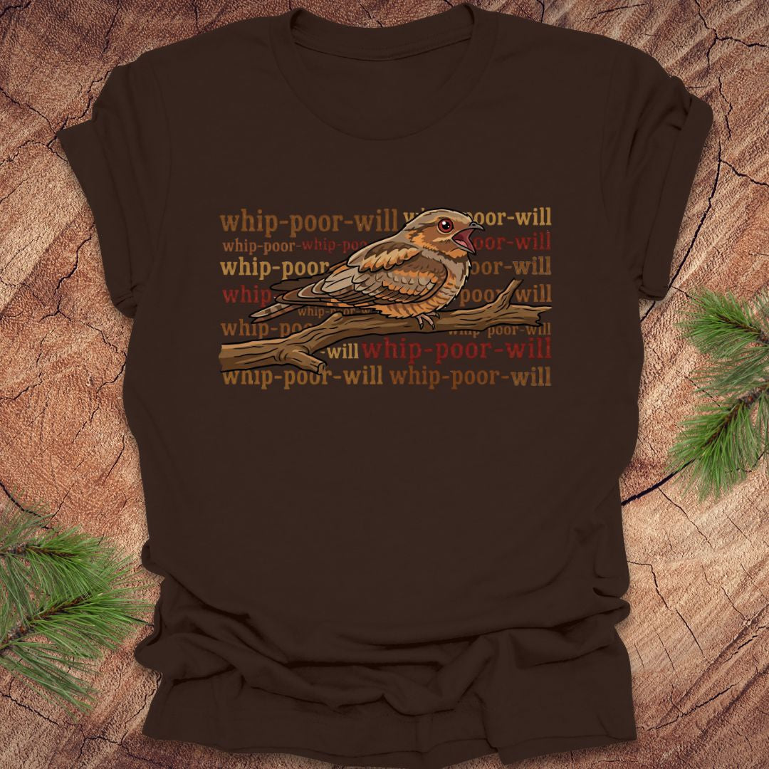 Brown t-shirt with a bird graphic and 'whip-poor-will' text on a wooden surface.