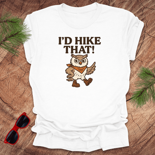 A white t-shirt with a graphic of an owl wearing a hat and the text 'I'D HIKE THAT!' printed above.