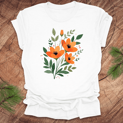 White t-shirt with orange floral design on a wooden surface