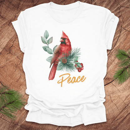 White t-shirt with a red cardinal and 'Peace' text on a wooden surface