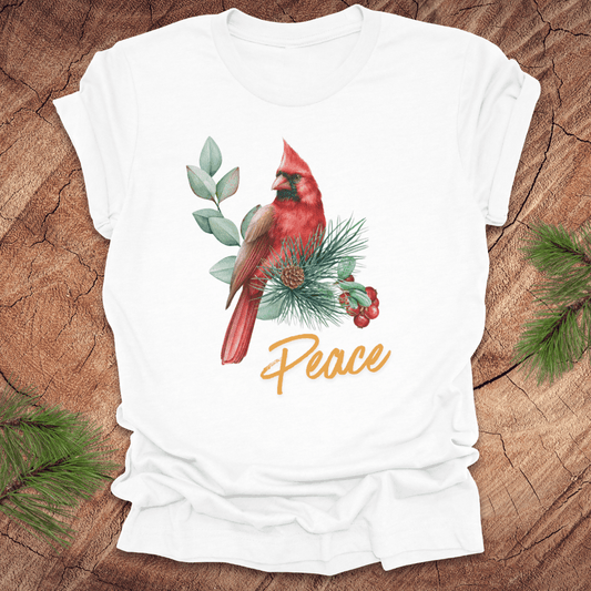 White t-shirt with a red cardinal and 'Peace' text on a wooden surface