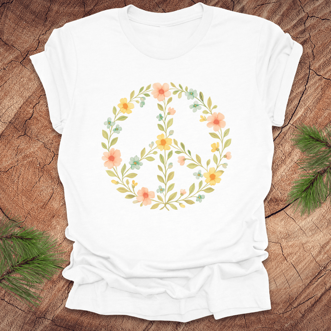 White t-shirt with a peace sign made of flowers on a wood background.