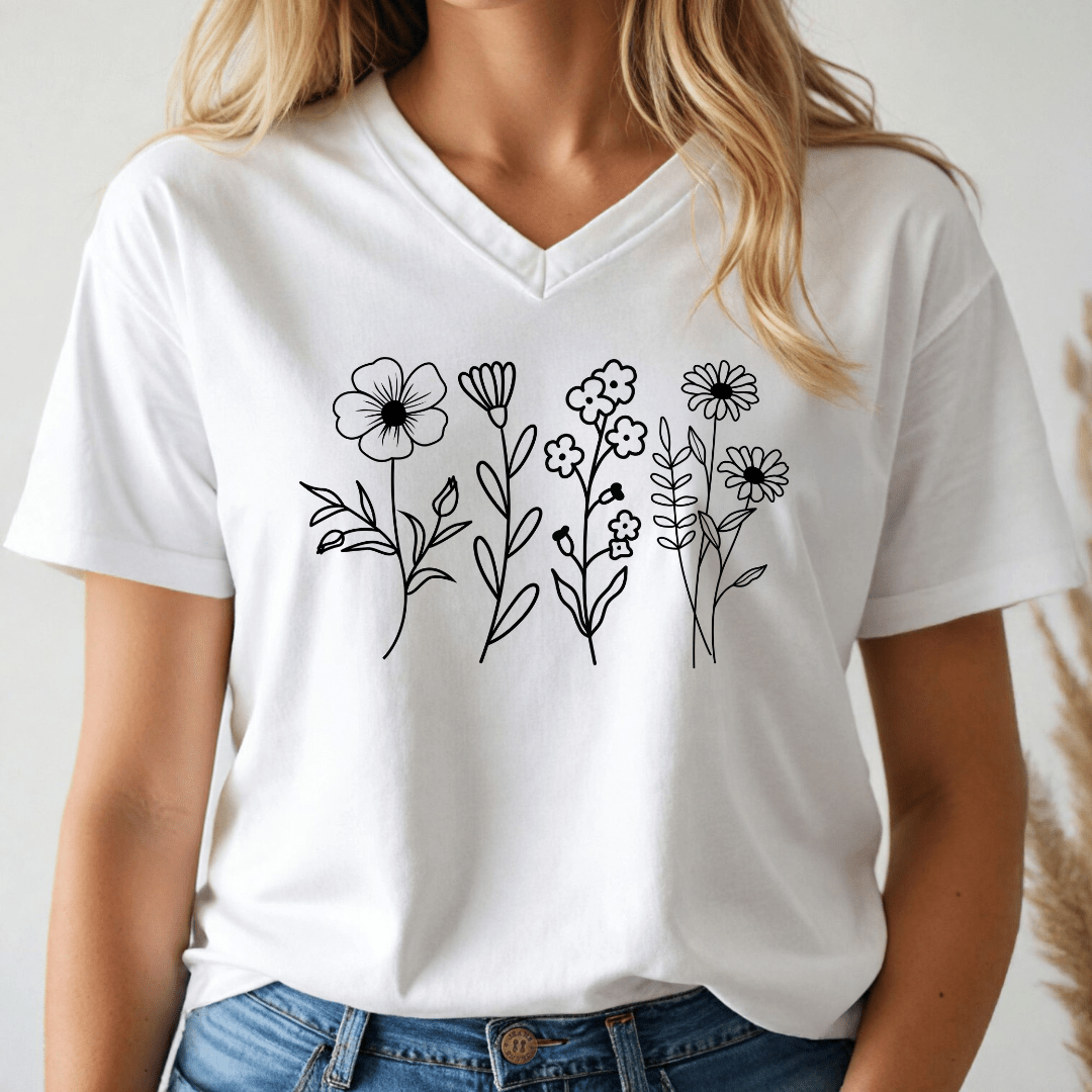 White vneck t-shirt with black floral designs worn by a person on a plain background