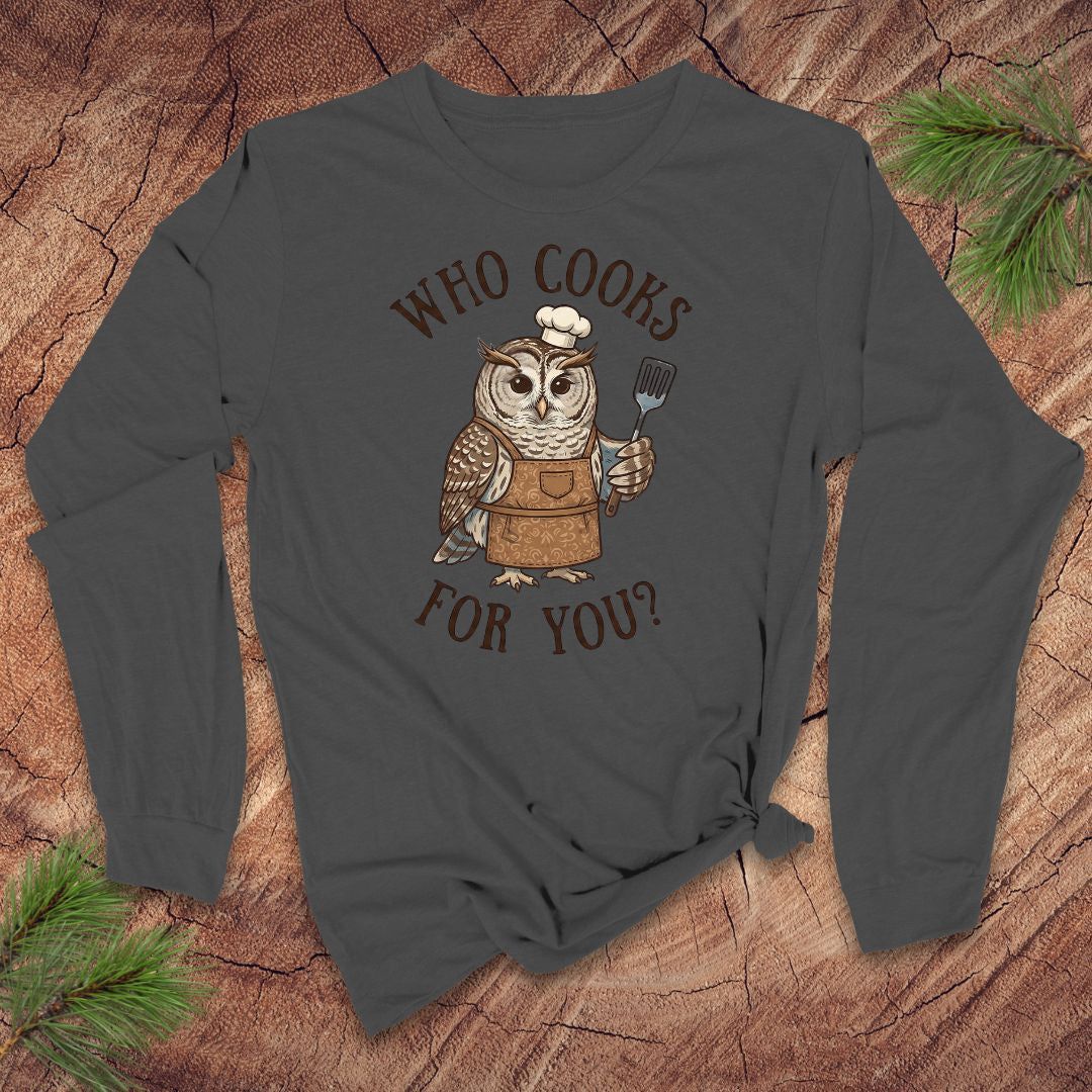 Dark grey long-sleeve shirt with an owl graphic and text 'who cooks for you' on a wooden surface
